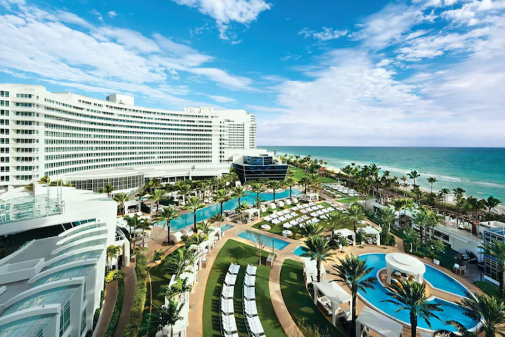 View of the Fontainebleau Miami Beach's main building, grounds and pools, and beach and ocean in the background