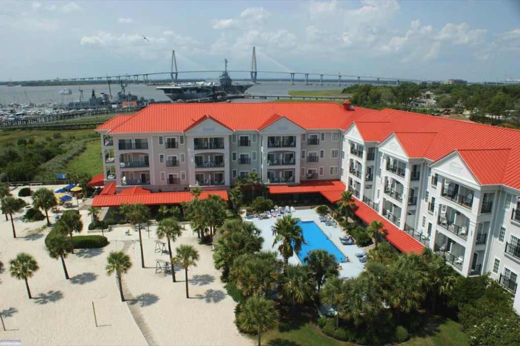 Aerial view of the Harborside at Charleston Harbor Resort and Marina with Naval ship and bridge in the background
