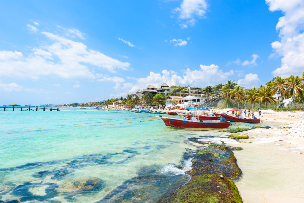 Boats on the shore of Playa del Carmen, México, a perfect warm weather babymoon destination