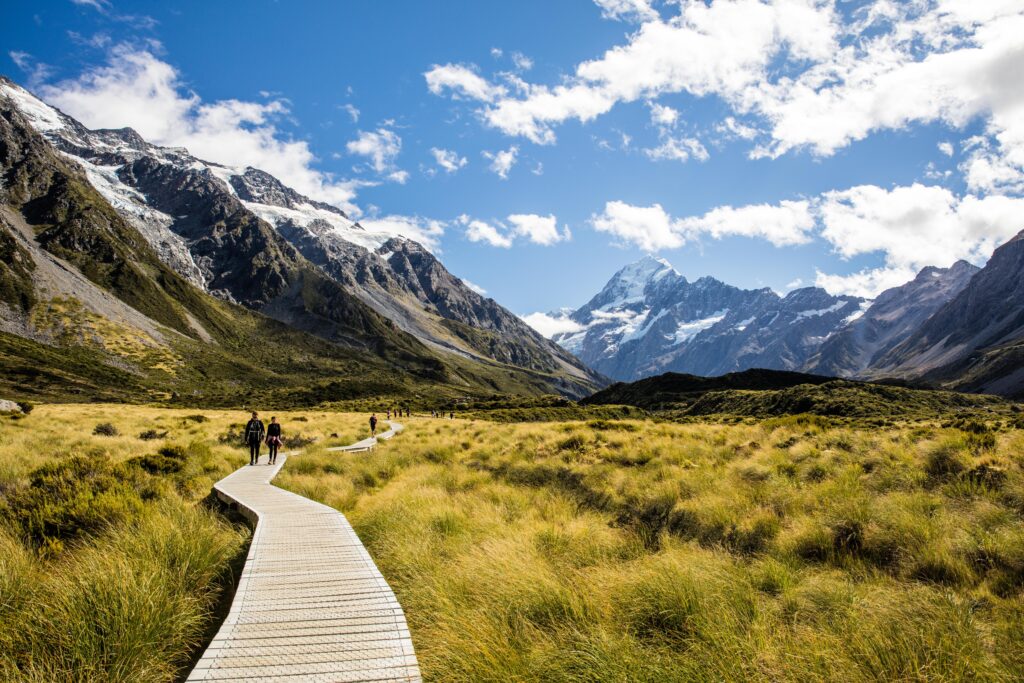 People strolling on wooden boardwalk in Aoraki/Mount Cook National Park, New Zealand