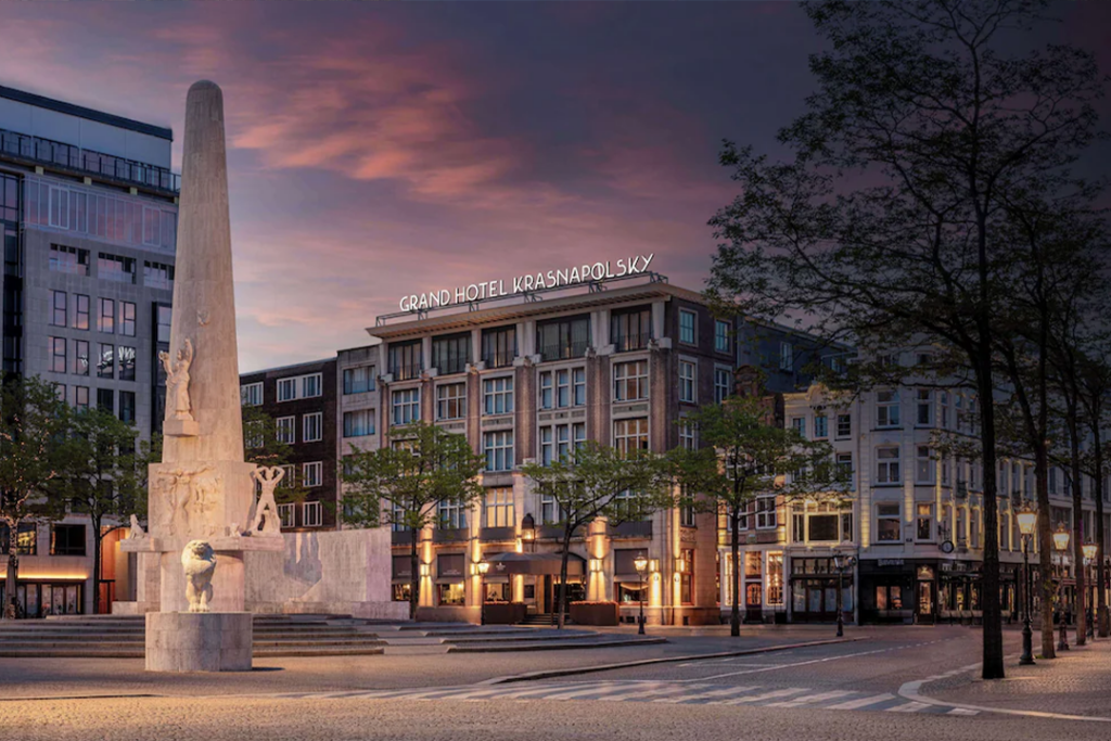 Front exterior of the Anantara Grand Hotel Krasnapolsky Amsterdam with monument in front of the hotel