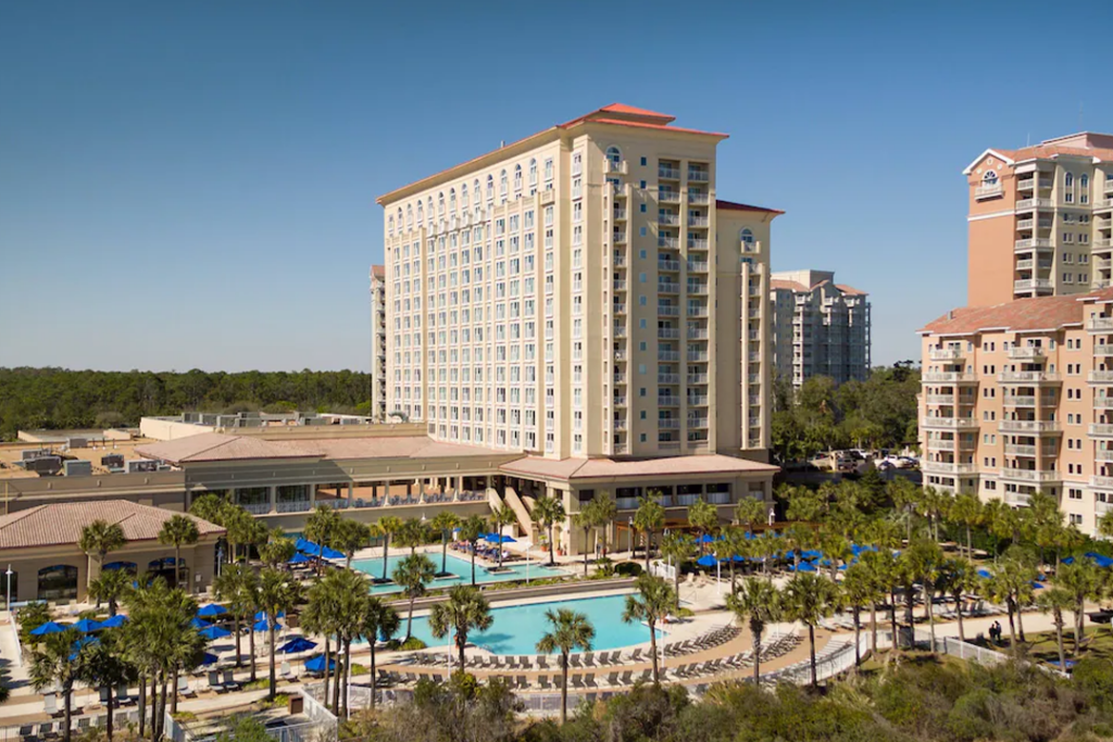Aerial view of the Marriott Myrtle Beach Resort & Spa at Grande Dunes with 2 pools and palm trees in the foreground