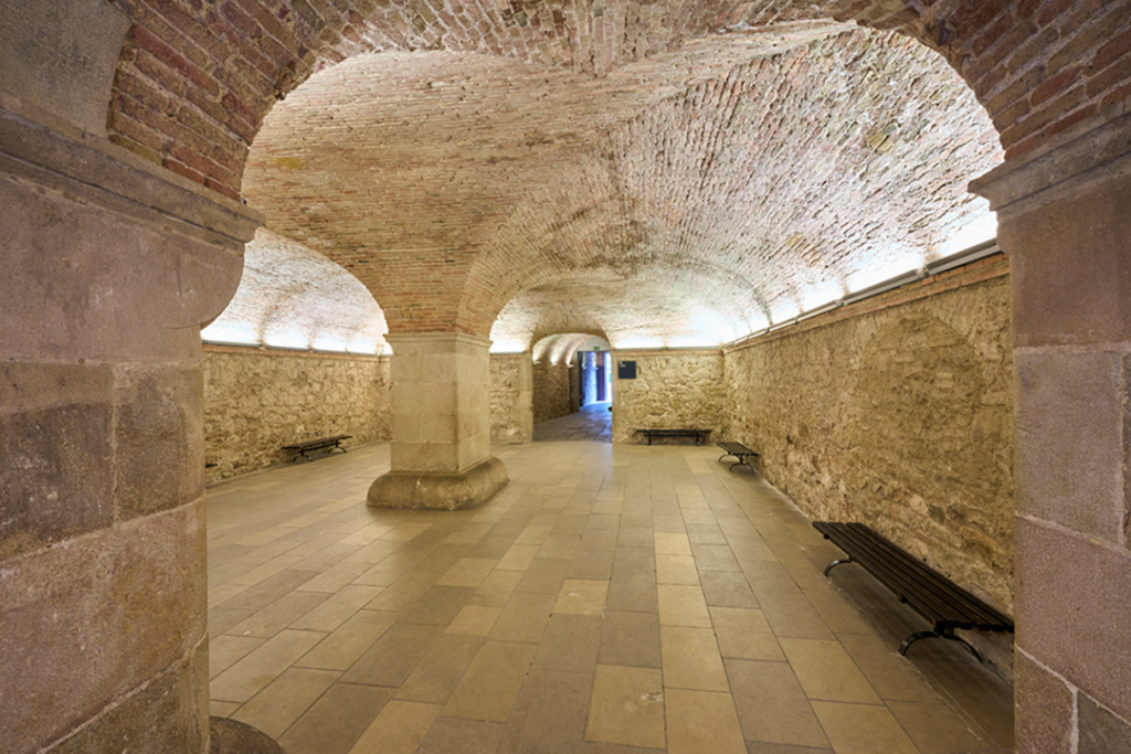 Ground floor space of the Palau Baró de Castellet covered with a four-pier brick vault supported by a large central pillar
