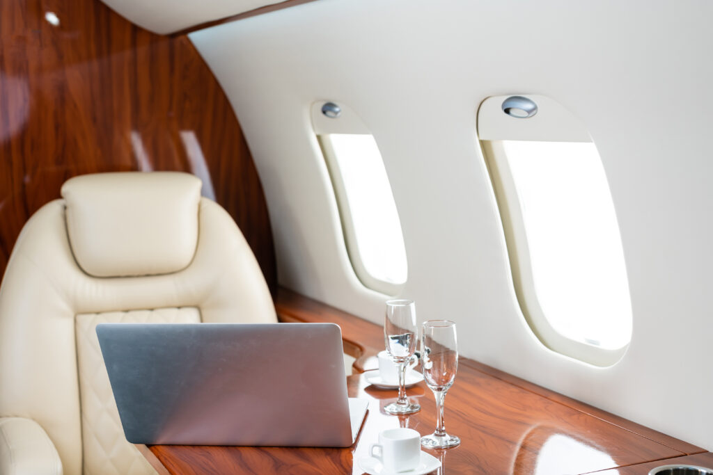 First class airline seat with table, laptop, and champagne glasses