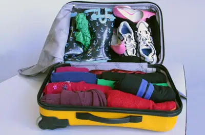 Suitcase With Rolled Clothes And Shoes