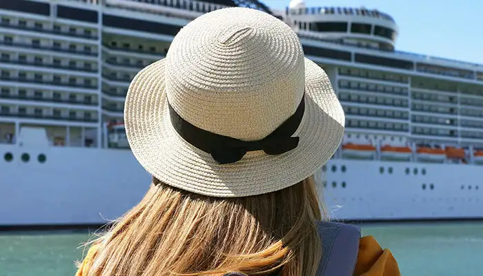 Person, as seen from behind, looking out at a docked cruise ship