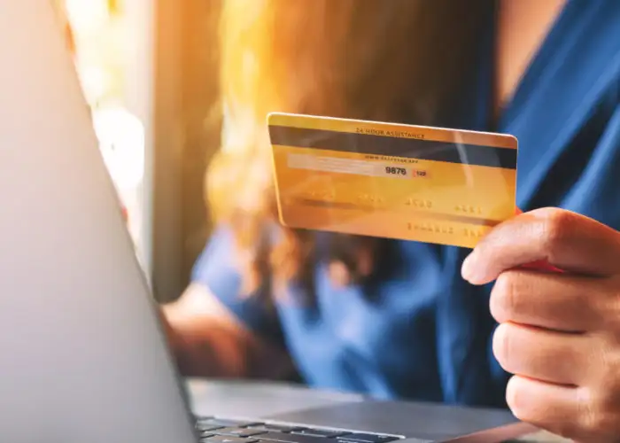Close up of person making a purchase on the computer with credit card
