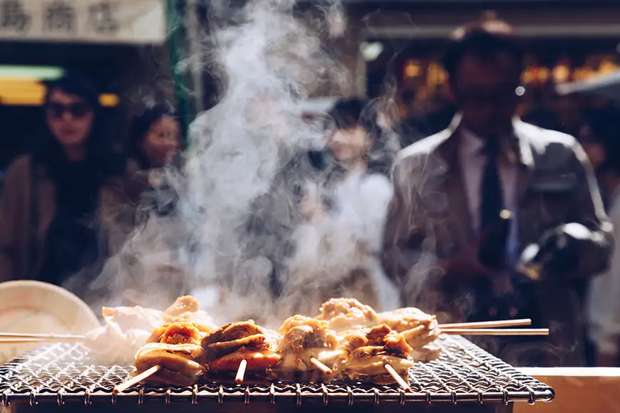 grilled seafood scallop and sea urchin eggs skewer with smoke, japanese street food at tsukiji fish market