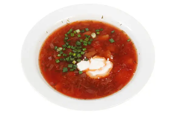 What gives traditional borscht its color?