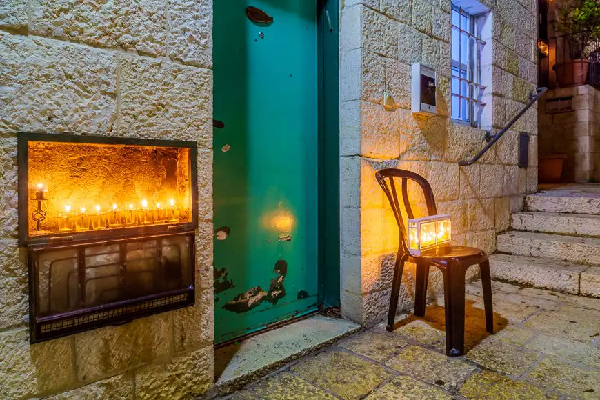 Traditional menorahs (hanukkah lamps) with olive oil candles, placed near the entrance, in jewish quarter,