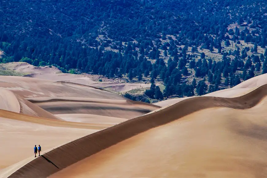 Couple hiking a dune ridge great sand dunes national park and preserve