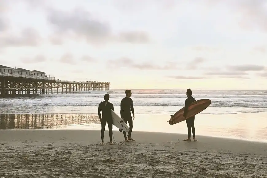 three men surfing in san diego california