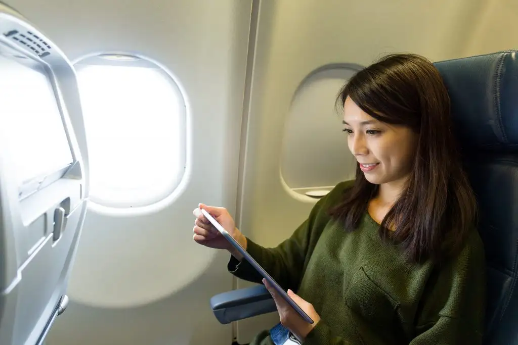 woman mobile device airplane seat