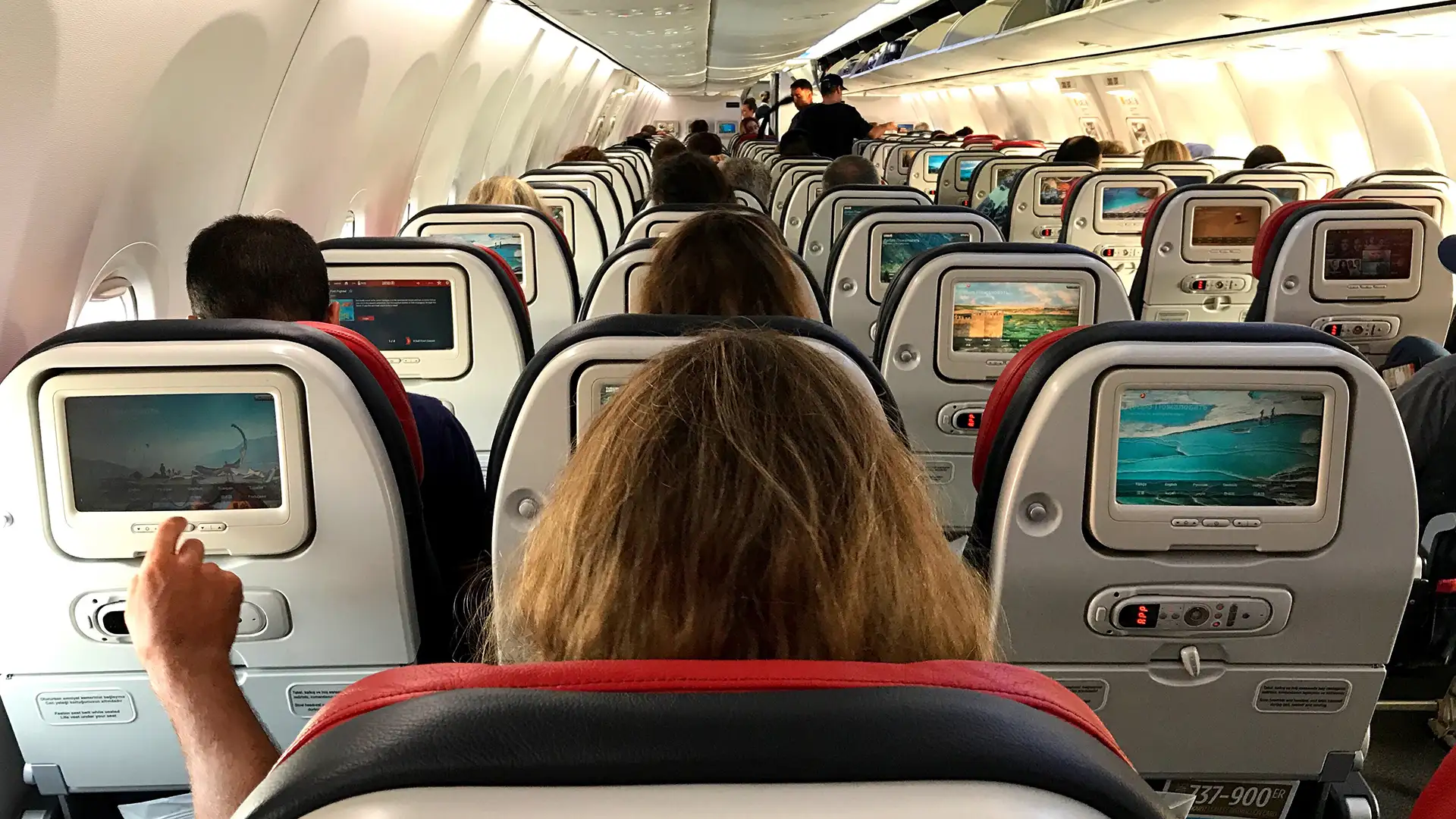 https://www.smartertravel.com/wp-content/webp-express/webp-images/doc-root/wp-content/uploads/2017/06/airplane-seats-woman-in-middle.jpg.webp