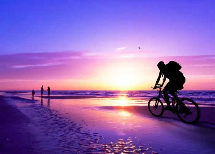 biking on the beach at sunset
