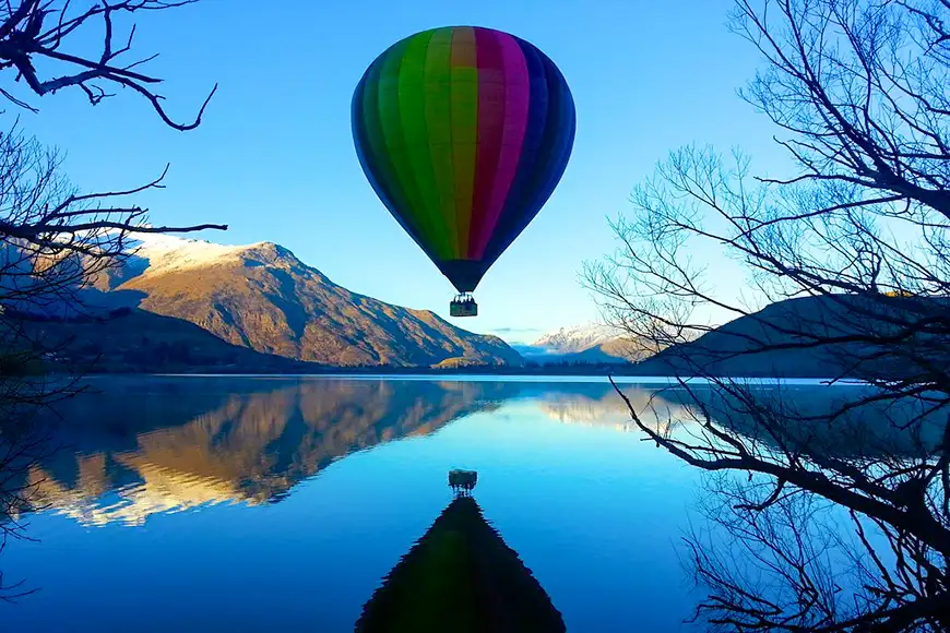 hot air balloon over lake in queenstown new zealand
