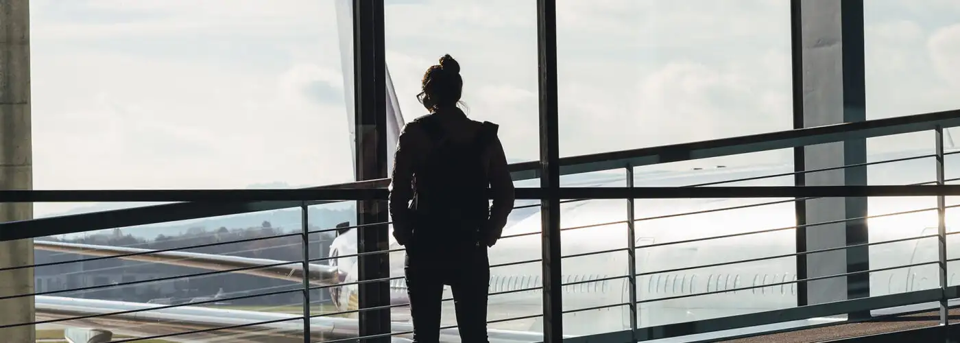 woman looking out airport window.