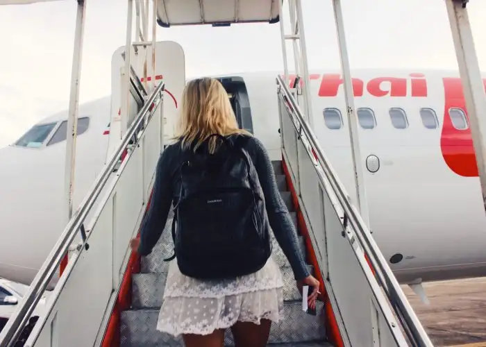 woman boarding plane wearing backpack