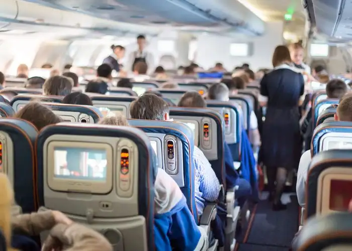 flight attendant moving through airplane cabin