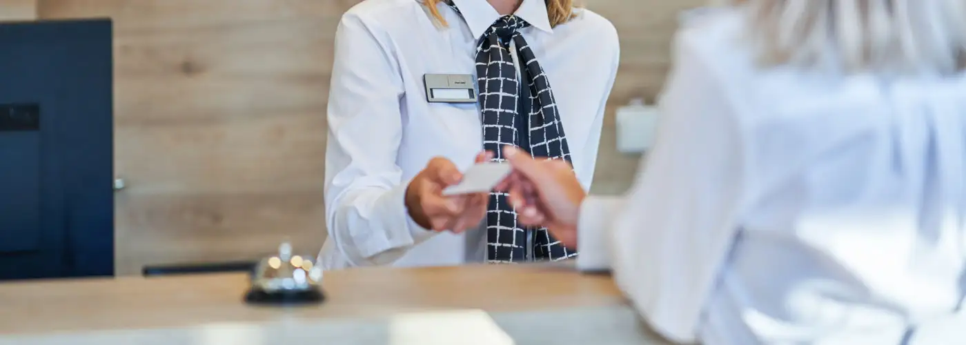 Woman checking in at front desk of hotel