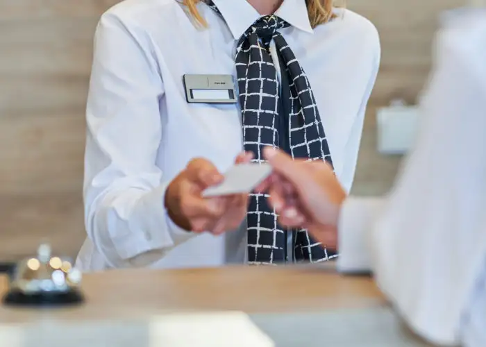 Woman checking in at front desk of hotel