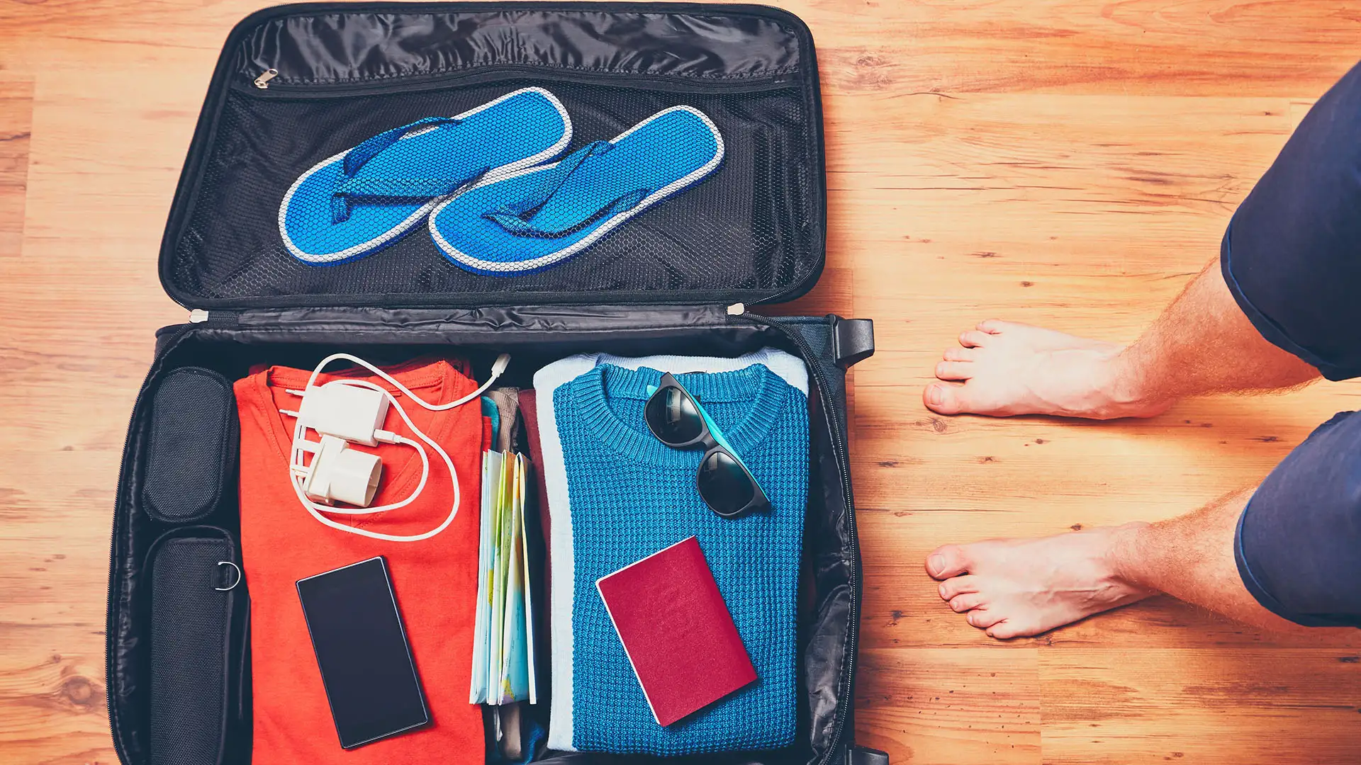 https://www.smartertravel.com/wp-content/webp-express/webp-images/doc-root/wp-content/uploads/2018/12/neatly-packed-suitcase-with-feet.jpg.webp