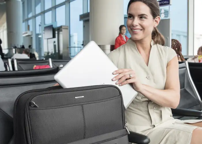 woman taking laptop out of suitcase