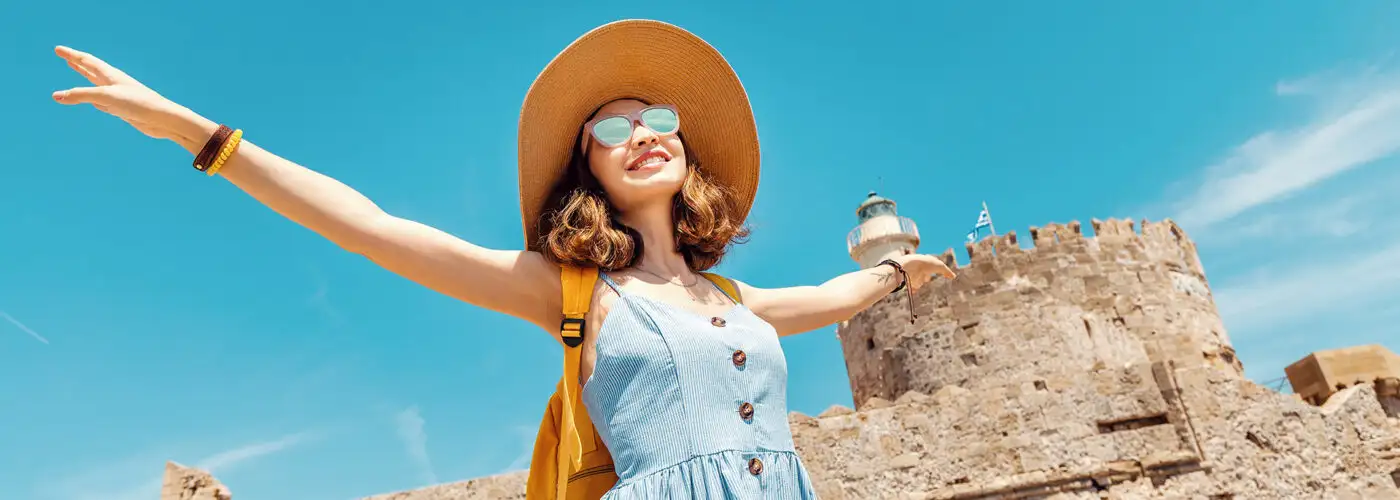 woman tourist arms out happy sunglasses sunny