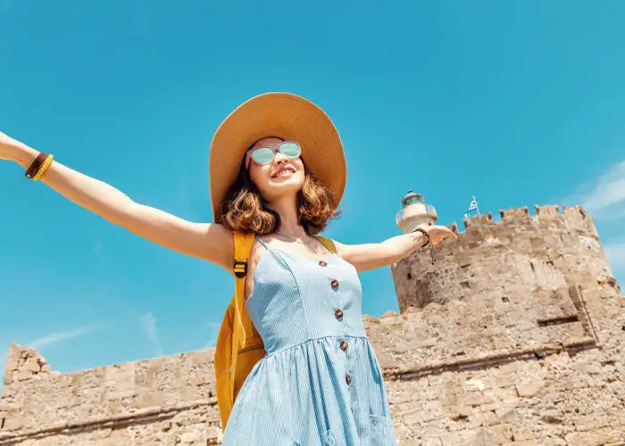 woman tourist arms out happy sunglasses sunny