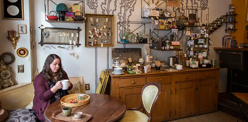 woman with mug at random tearoom and curiosity shop.