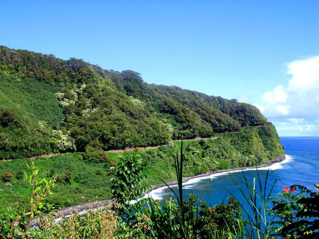 road to hana view of cliffside highway and ocean with green lush mountains lanscape