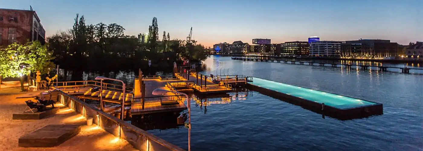 The Badeschiff pool in Berlin at night during a heat wave in Europe.