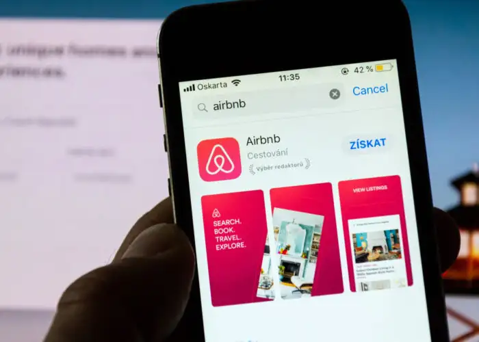 Airbnb logo and app on phone.