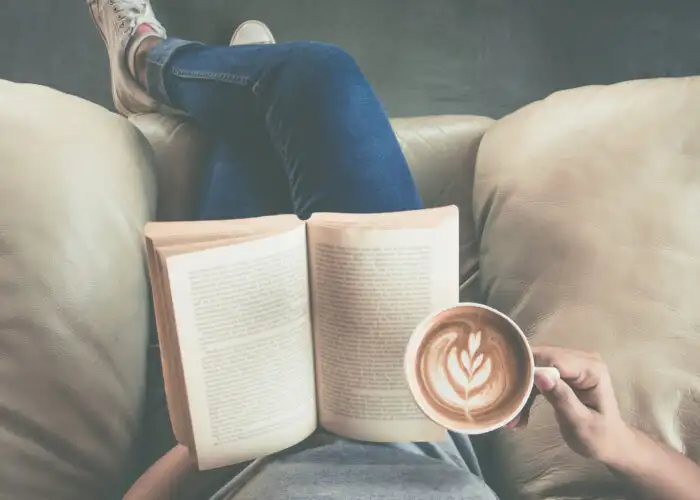 person reading book with coffee