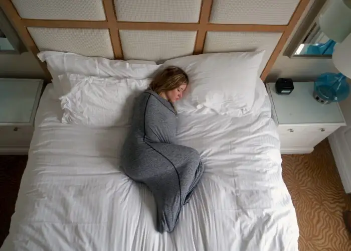 woman sleeping in bed with swaddle blanket