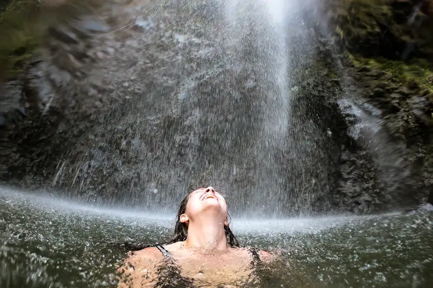 woman enjoying waterfall in hawaii
