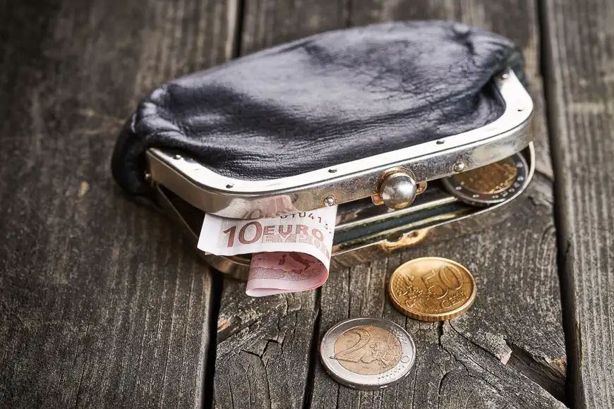 Purse with money on old rustic wooden table