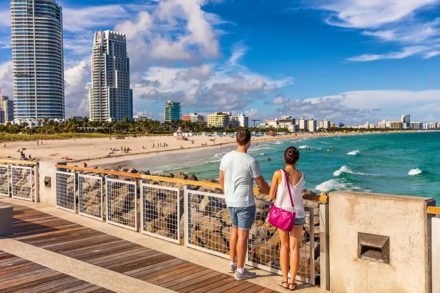 Miami beach tourists couple walking in South Beach, Miami, Florida.