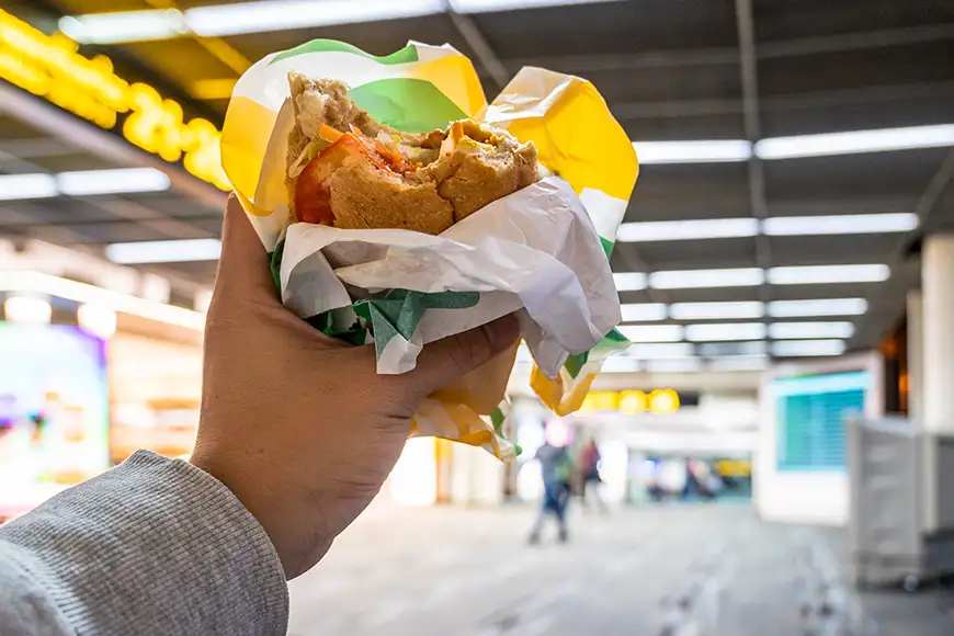 Man hand holding Burger at airport terminal