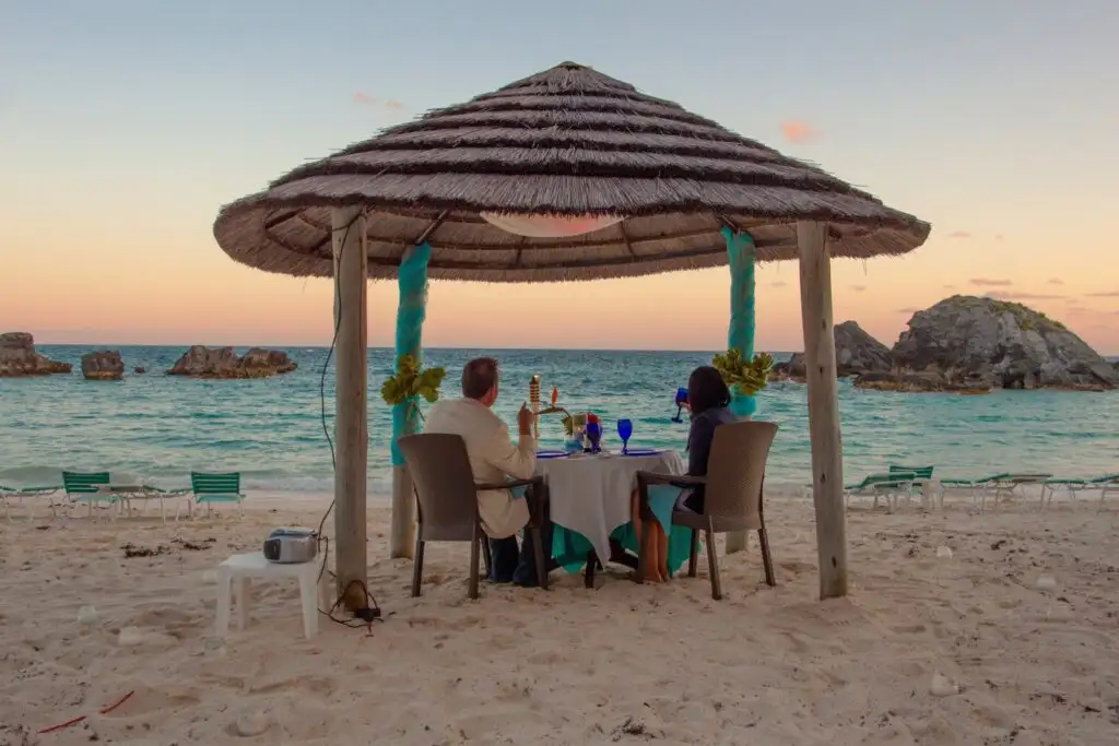 couple on beach in bermuda having dinner