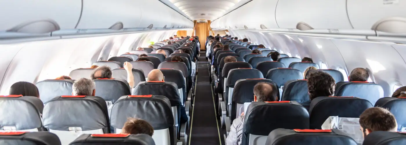 Interior of commercial airplane with unrecognizable passengers on their seats during flight