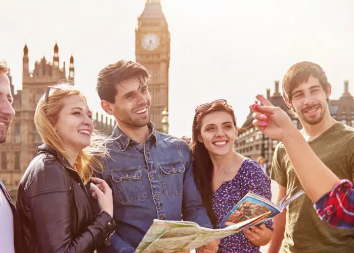 Group of friends talking over a map in front of Big Ben in London