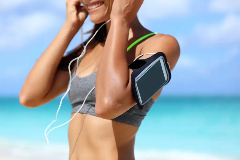 Women wearing a smartphone fitness arm band on beach