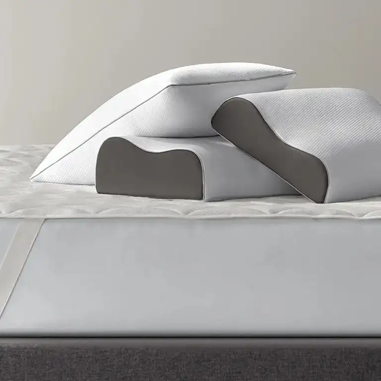 Three Sleep Number True Temp Ultimate Pillows stacked on top of a mattress