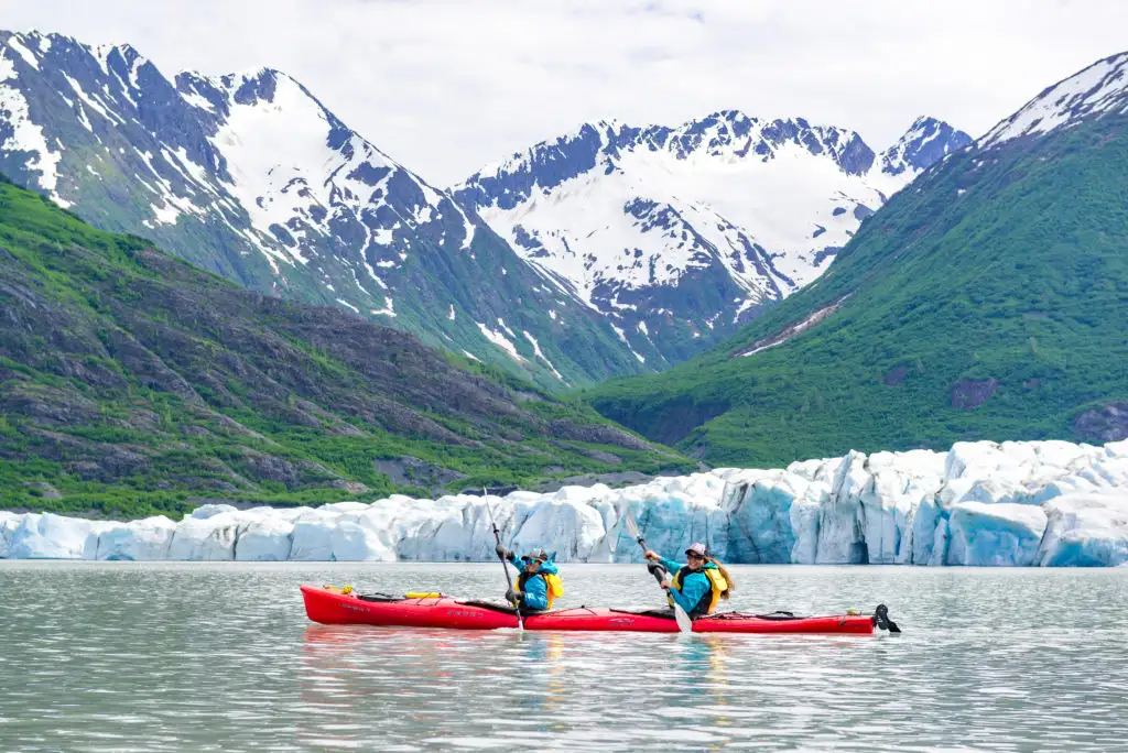 Two people kayaking next to Spencer Glacier outside of Anchorage, Alaska