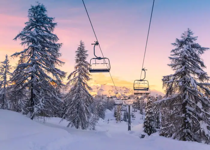 Ski lift on a snowy mountain at sunrise