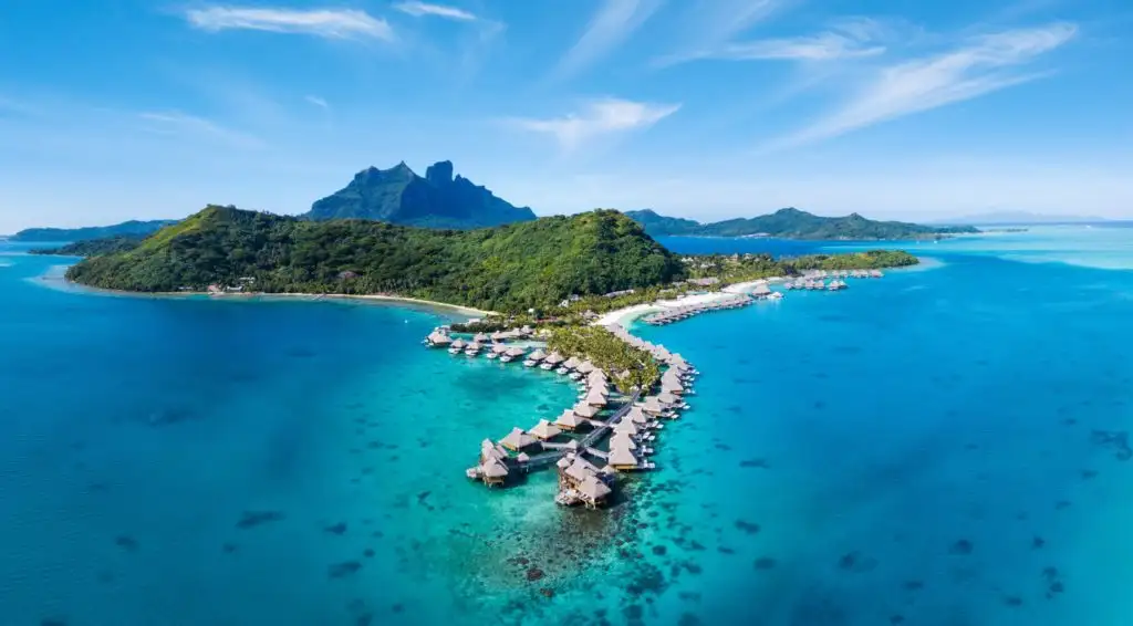 Aerial view of the overwater bungalows and greenery at the Conrad Bora Bora Nui