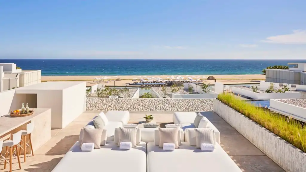 Outdoor patio set up overlooking the beach at Viceroy Los Cabos