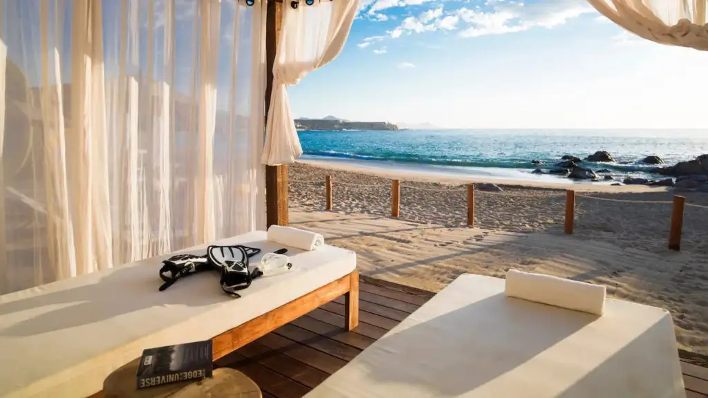 Two massage tables beneath a white tent overlooking a beach at Esperanza resort in Cabo