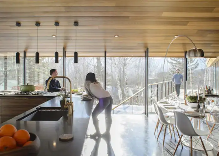 People relaxing in the kitchen of The Stowe Glass House in Stowe Vermont
